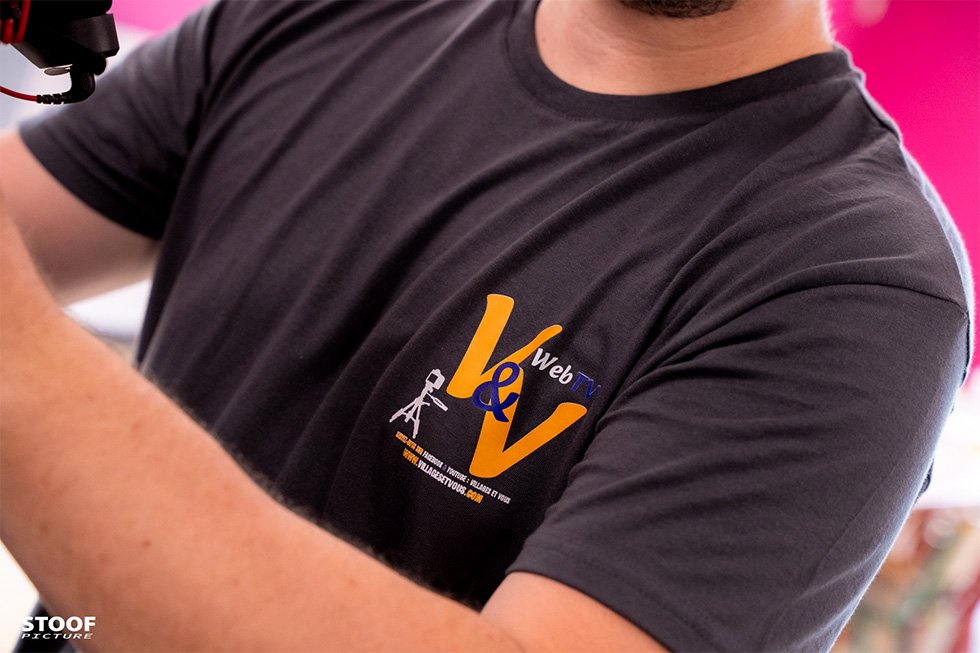 Logo Villages&Vous WebTV sur le t-shirt de Thibault Moës, symbole de sa chaîne locale à Liège.